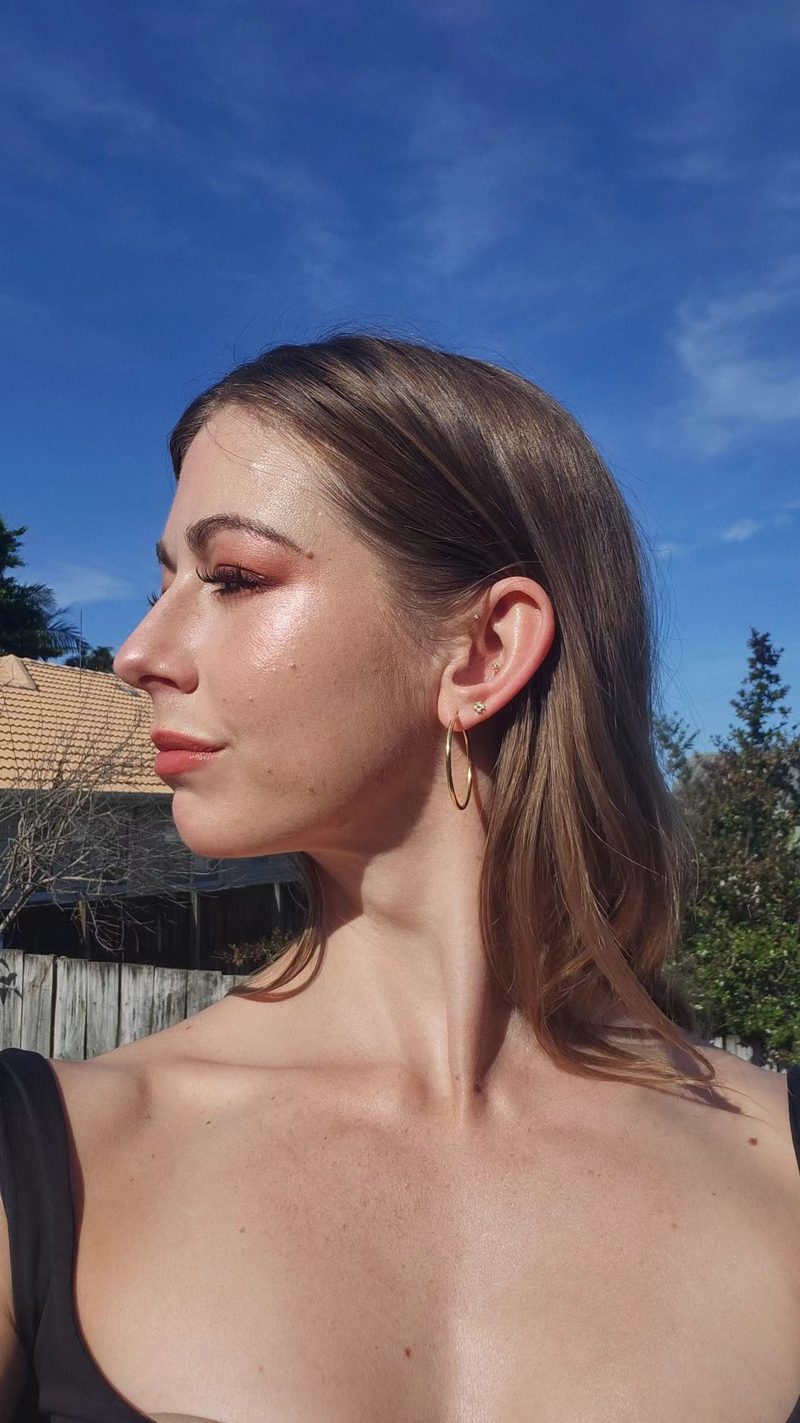 Profile portrait outdoors, soft makeup with a warm bronze eye